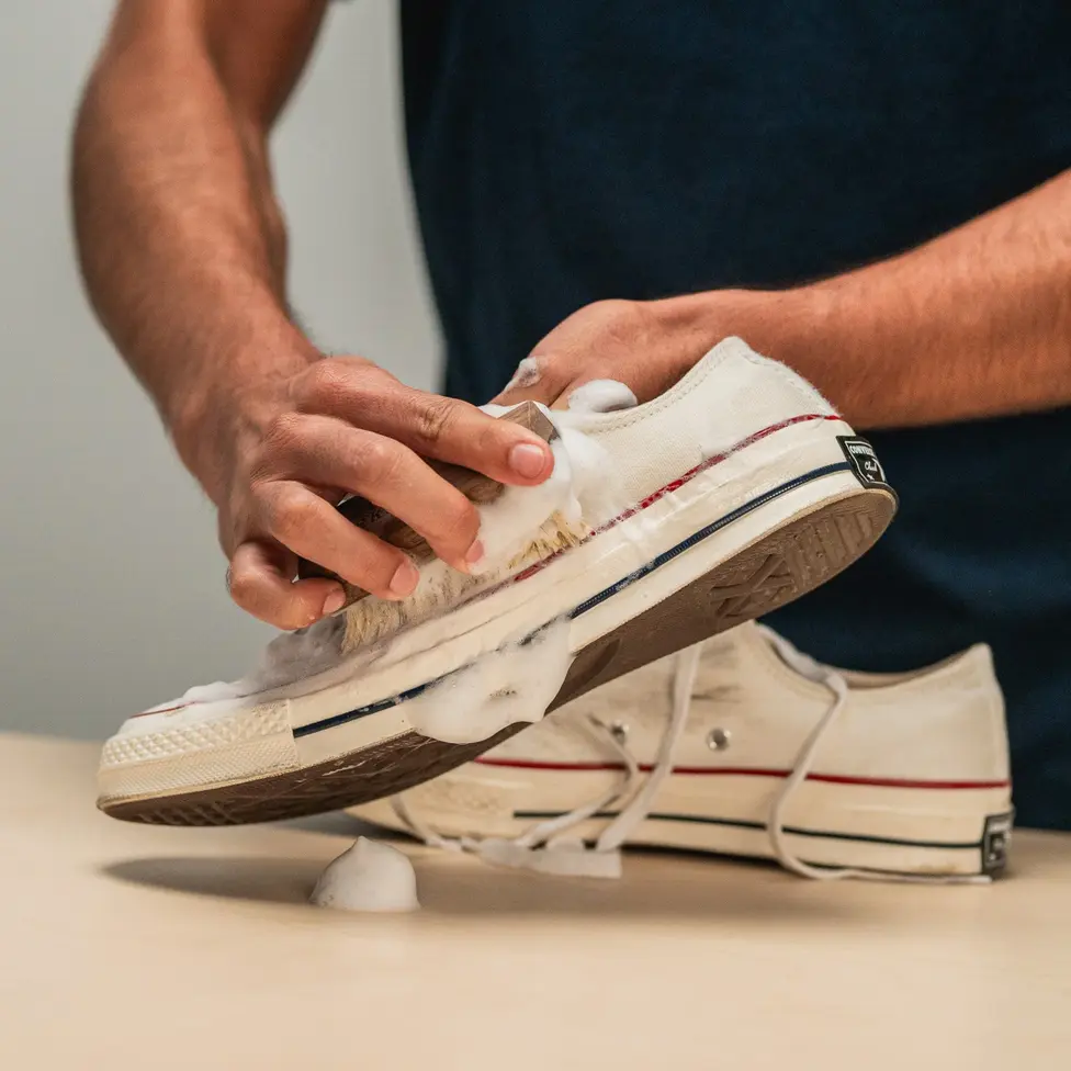 A sneaker being cleaned by hand